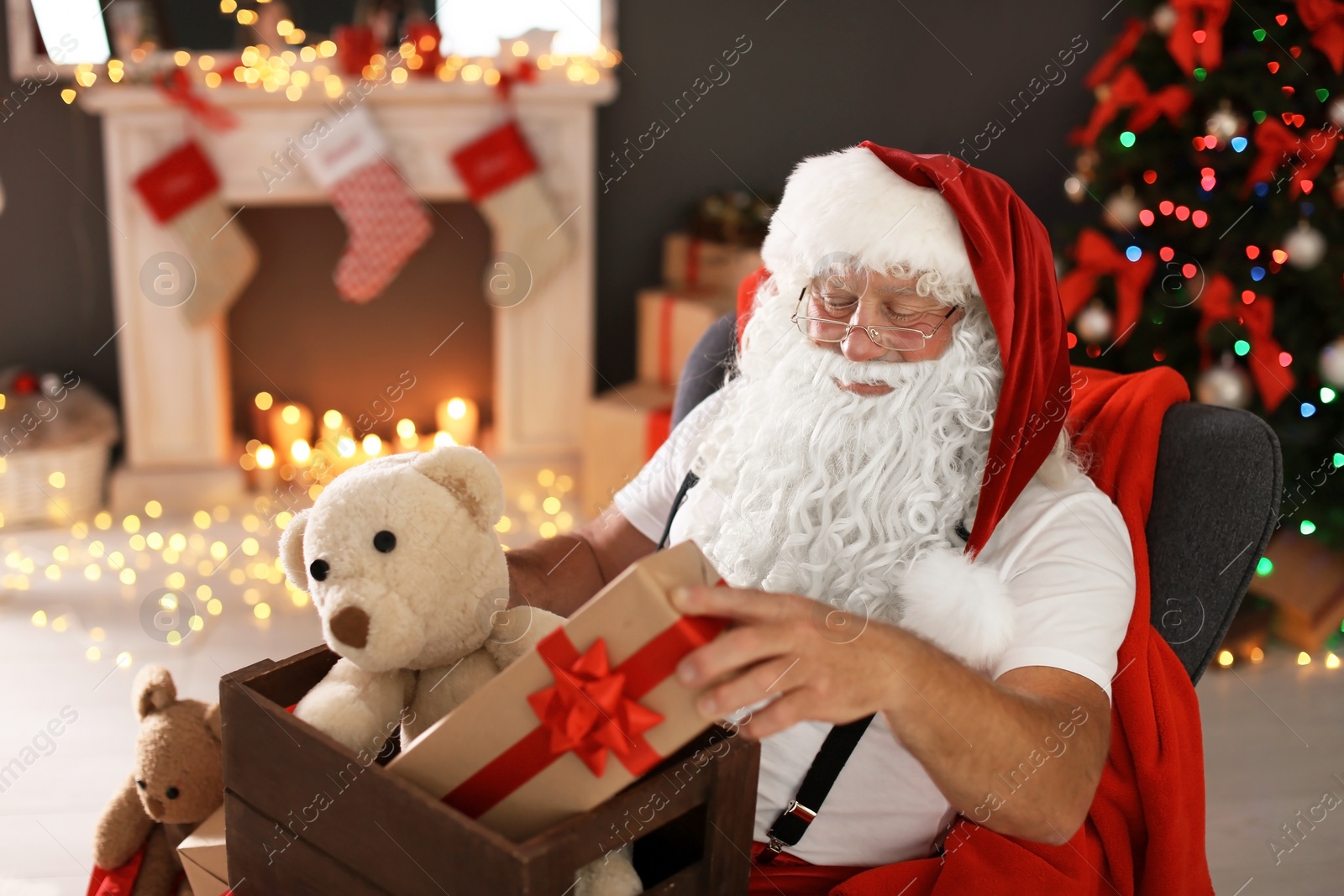 Photo of Authentic Santa Claus holding wooden crate with gifts indoors