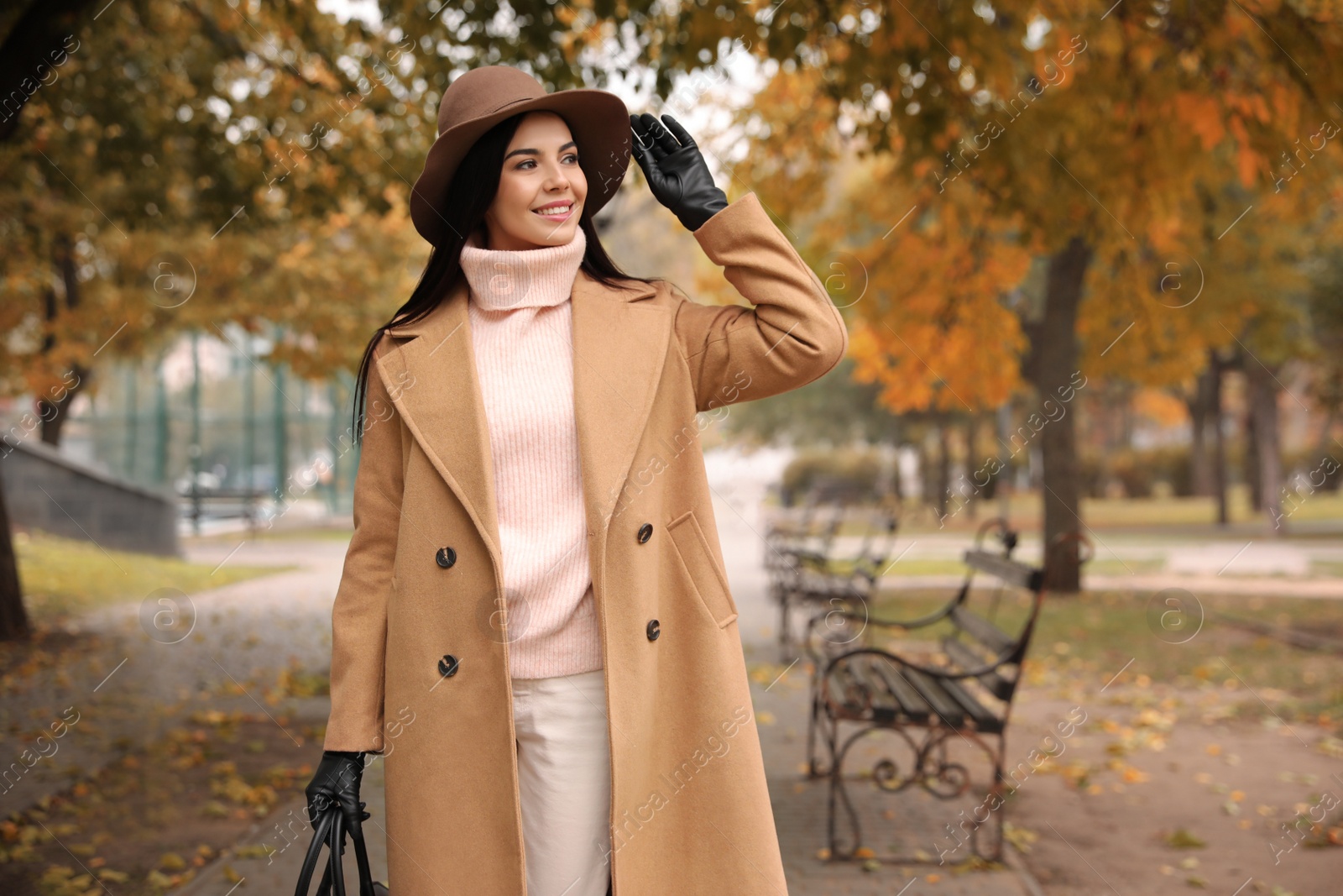 Photo of Young woman wearing stylish clothes in autumn park