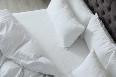Soft white pillows on comfortable bed. Interior design