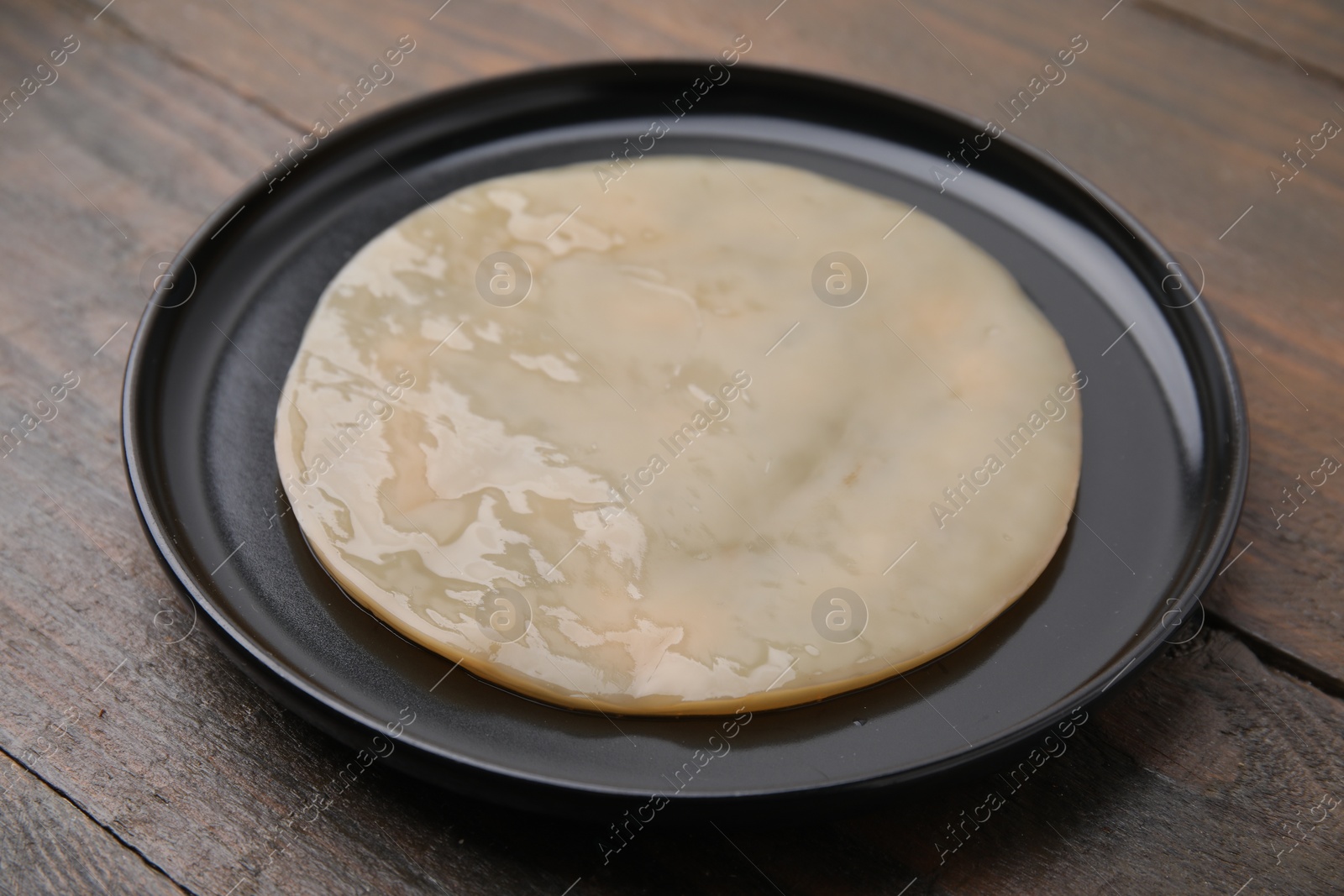 Photo of Making kombucha. Scoby fungus on wooden table, closeup