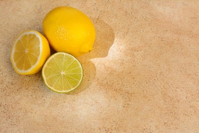Fresh ripe lemons and lime on light table, top view. Space for text