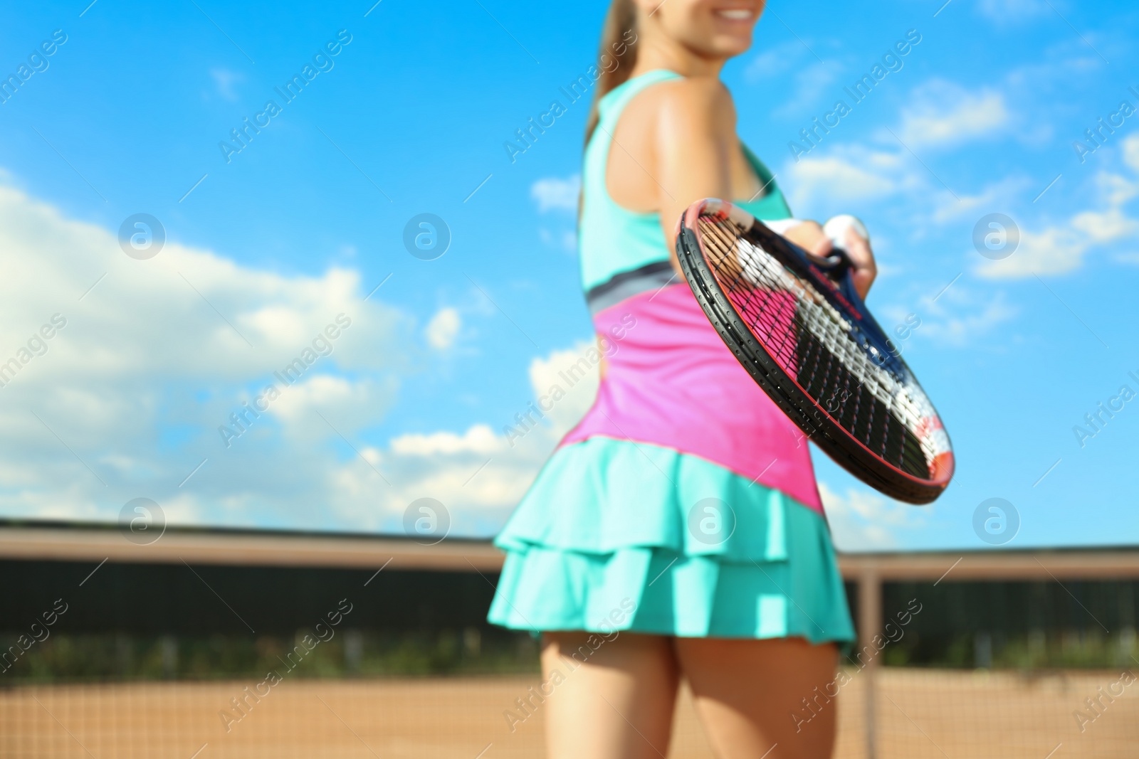 Photo of Sportswoman playing tennis at court on sunny day, closeup