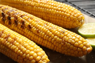 Photo of Tasty grilled corn with salt, closeup view