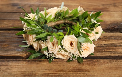 Wreath made of beautiful flowers on wooden table