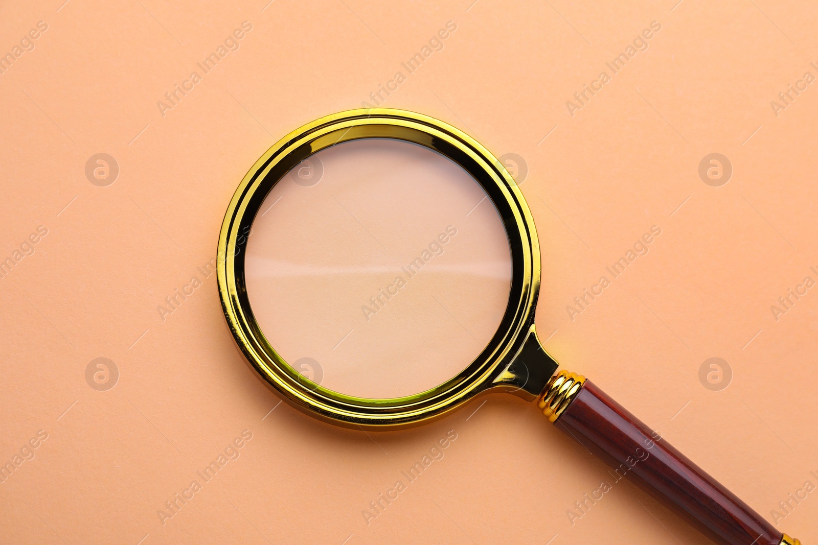 Photo of Magnifying glass on beige background, top view