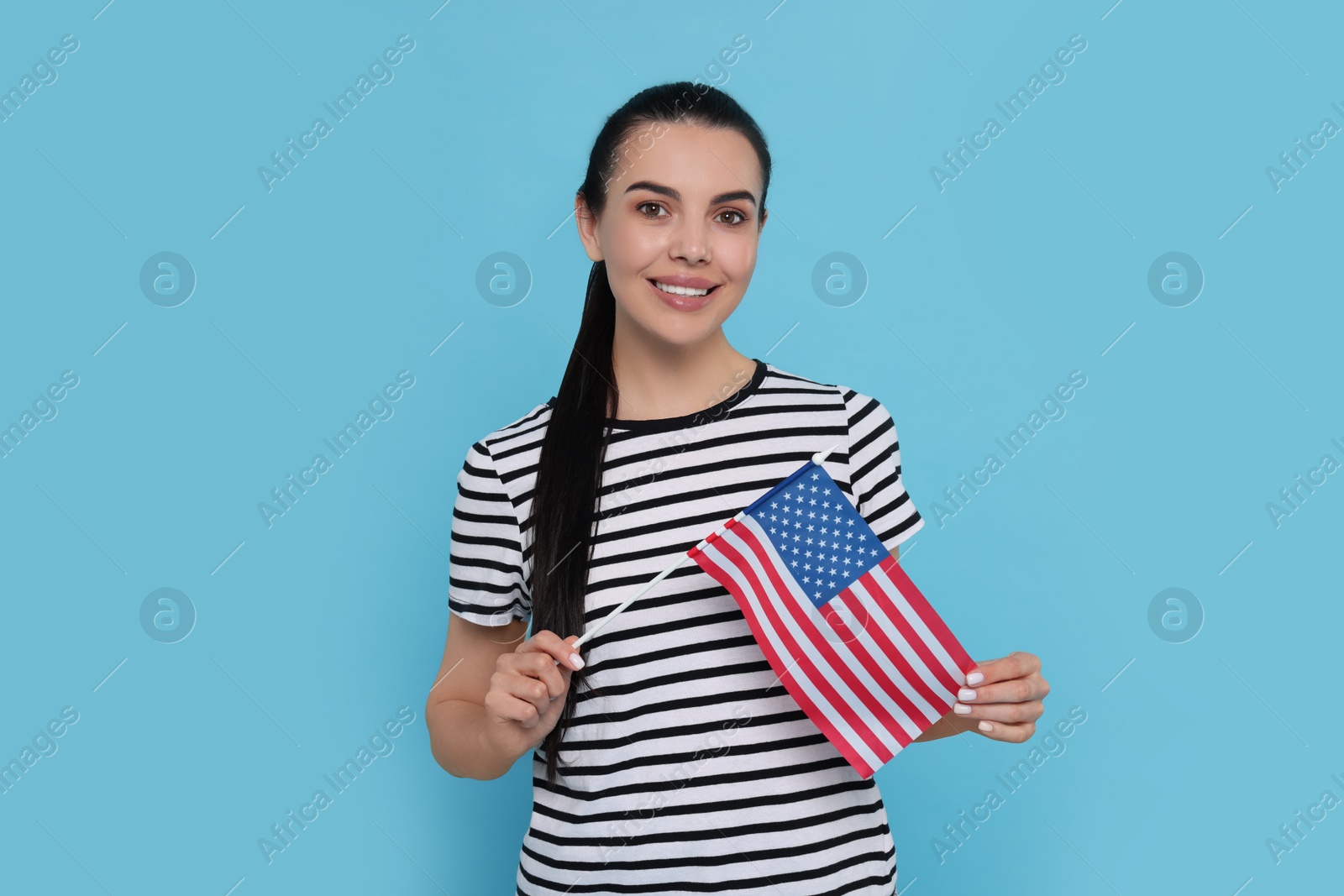 Photo of 4th of July - Independence Day of USA. Happy woman with American flag on light blue background