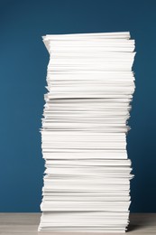 Photo of Stack of white paper sheets on blue background