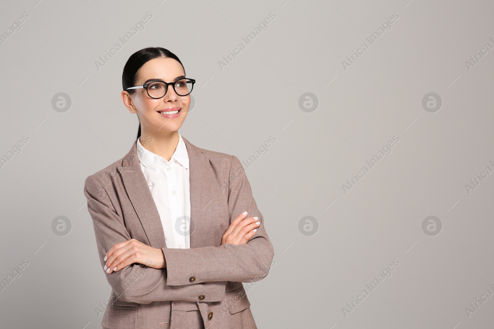 Photo of Beautiful real estate agent in nice suit on grey background. Space for text