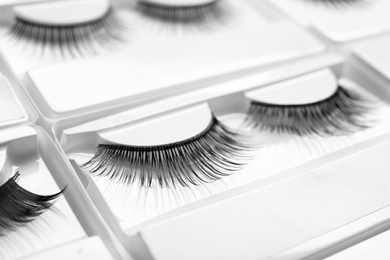 Photo of Set with false eyelashes in pack as background, closeup