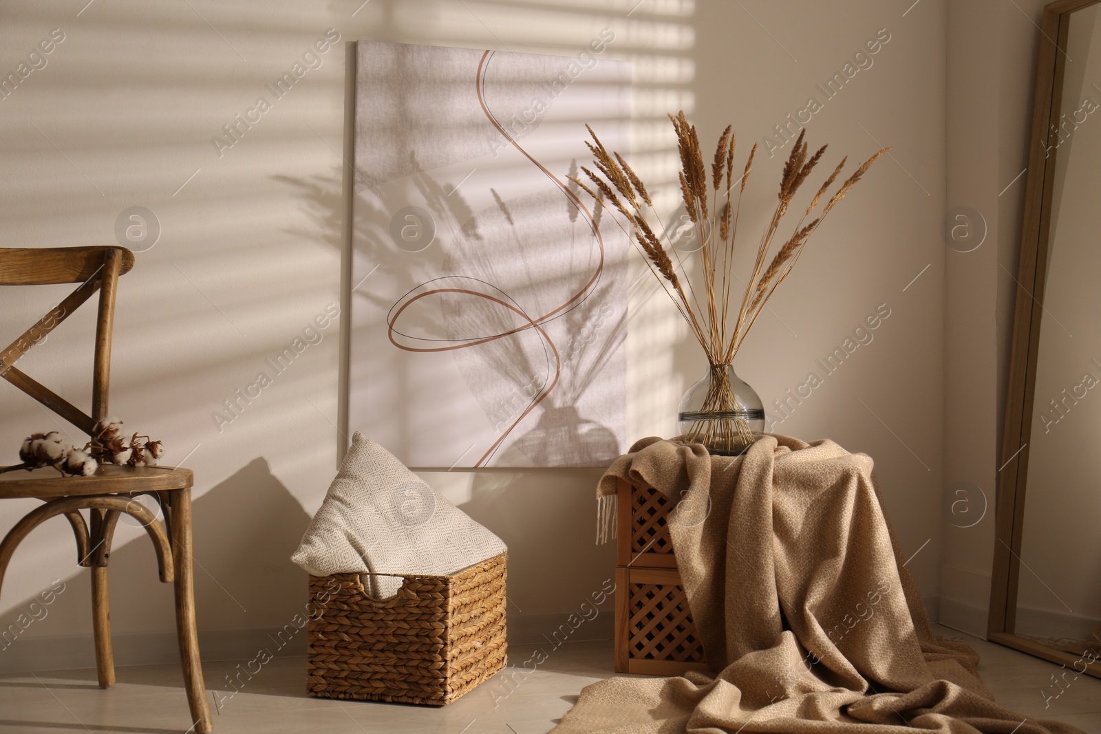 Photo of Vase with decorative dried plants and painting in stylish room interior