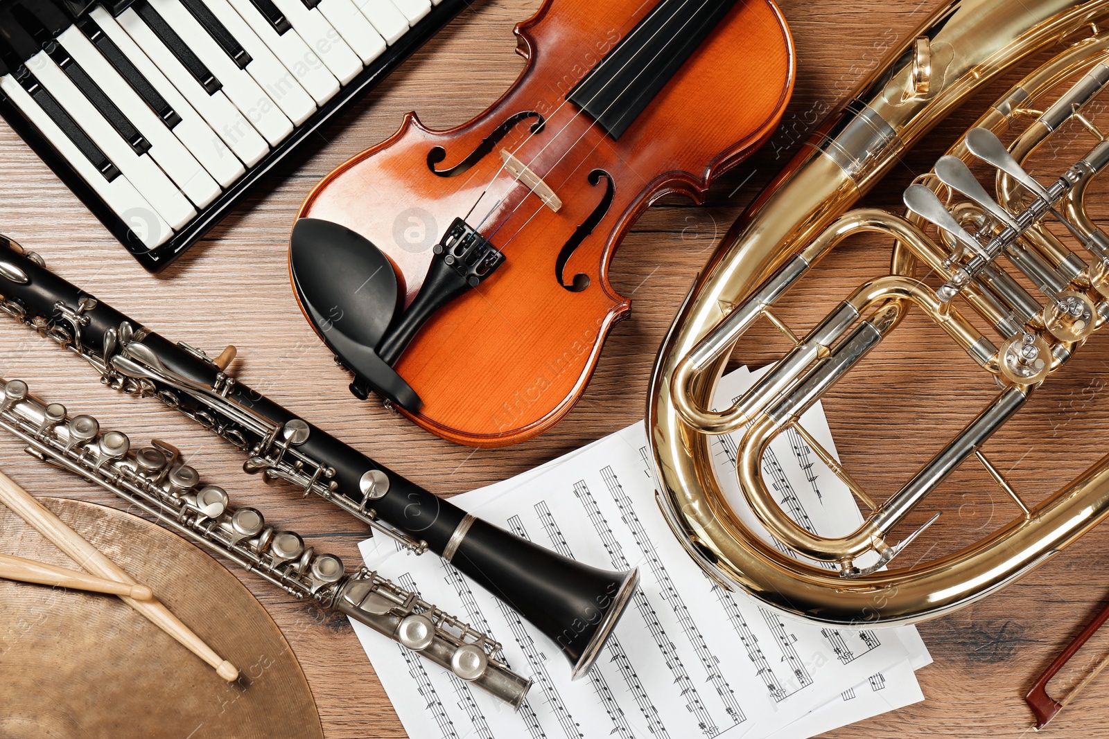 Photo of Set of different musical instruments on wooden background, flat lay