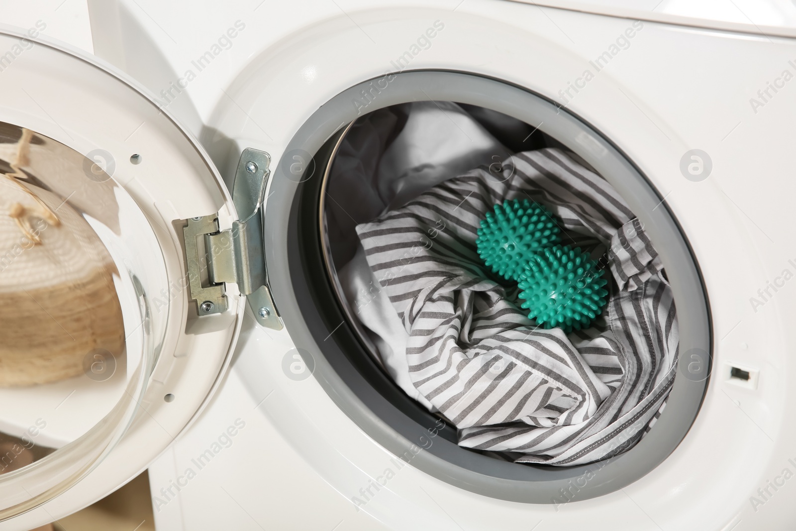 Photo of Green dryer balls and clothes in washing machine drum