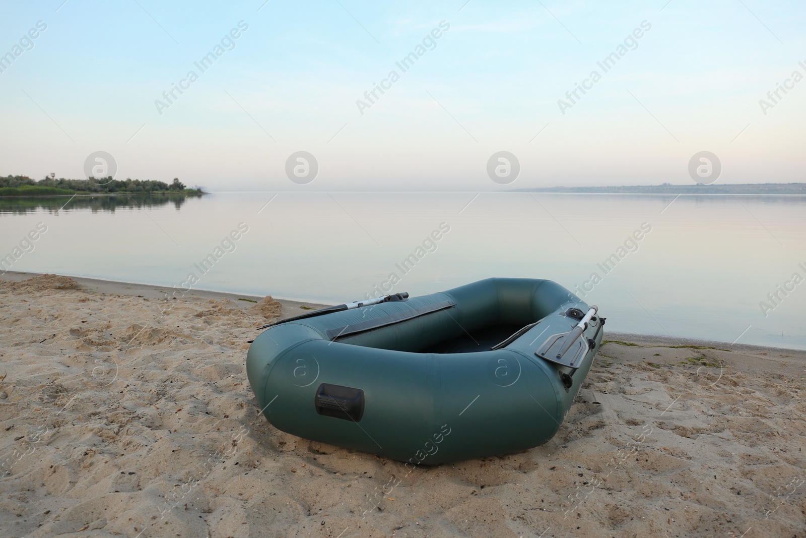 Photo of Inflatable rubber fishing boat on sandy beach near river