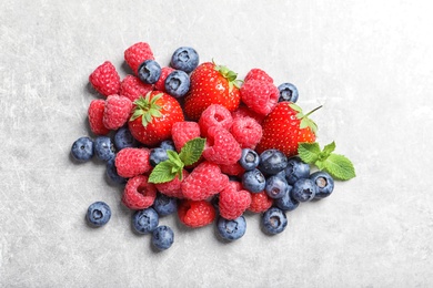 Photo of Raspberries, strawberries and blueberries on table, top view