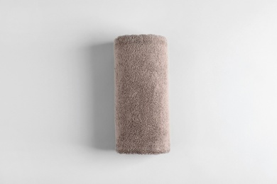Photo of Fresh fluffy rolled towel on grey background, top view