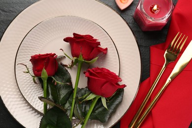 Photo of Place setting with candles and roses on grey textured table, flat lay. Romantic dinner
