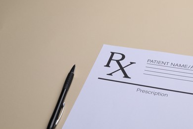 Photo of Medical prescription form and pen on beige background. Space for text