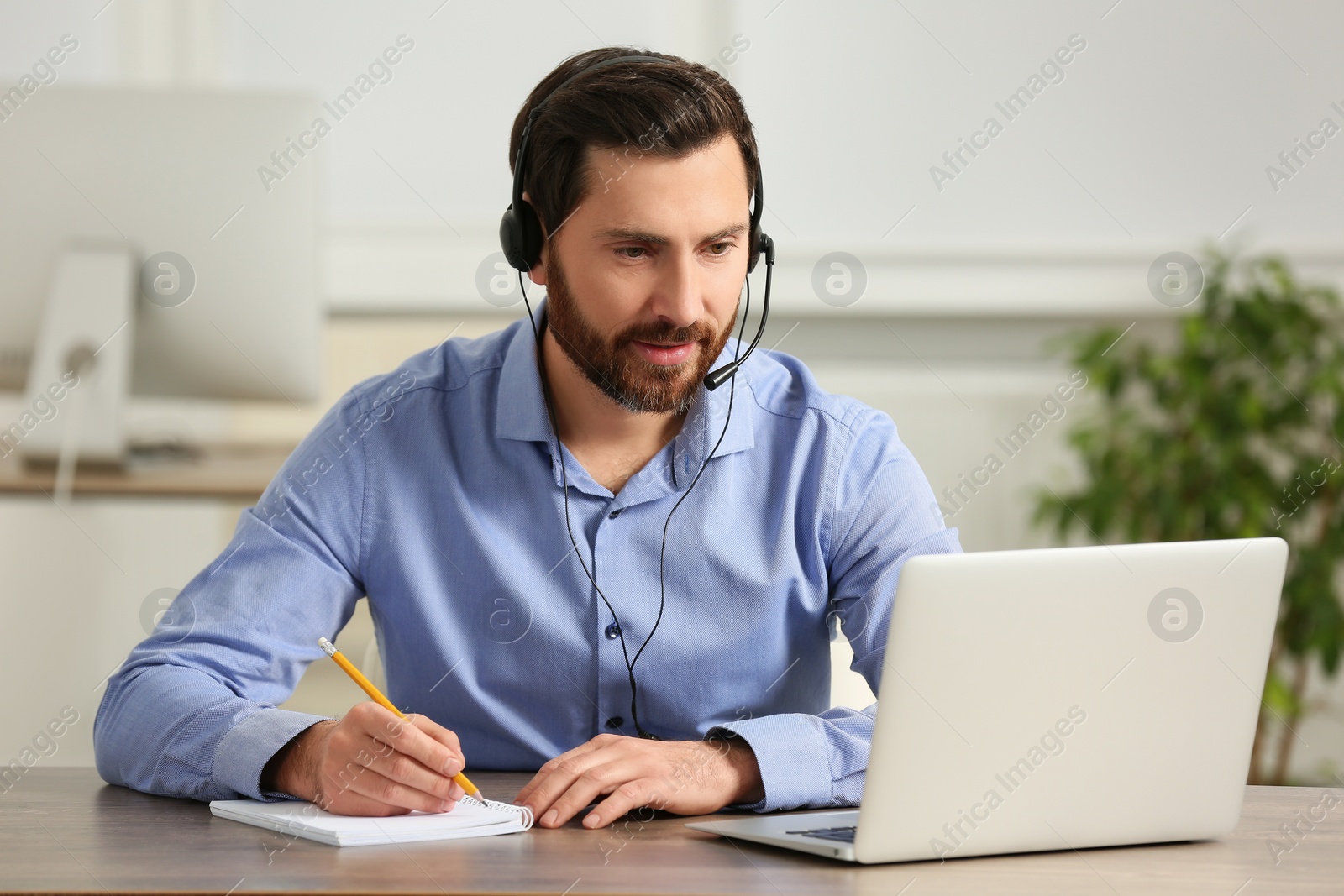 Photo of Hotline operator with headset working in office