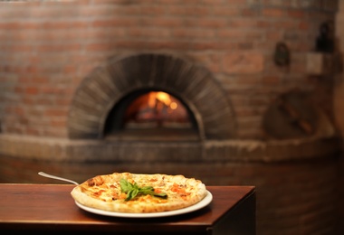 Photo of Tasty oven baked pizza on wooden table. Space for text