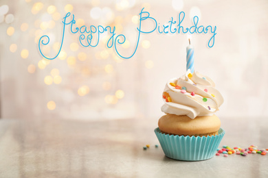 Delicious cupcake with candle on light table against blurred lights. Happy Birthday