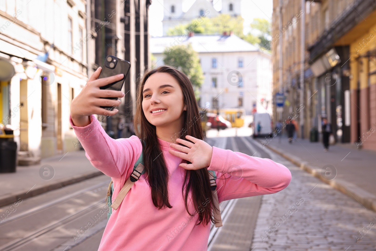 Photo of Travel blogger with smartphone streaming on city street