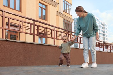 Photo of Happy nanny walking with cute little boy outdoors