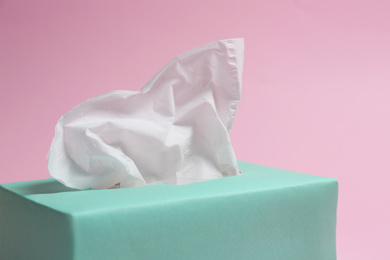 Photo of Box with paper tissues on pink background, closeup