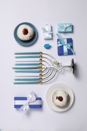 Flat lay composition with Hanukkah menorah and donuts on white background