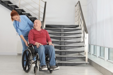 Nurse assisting senior man in wheelchair at hospital