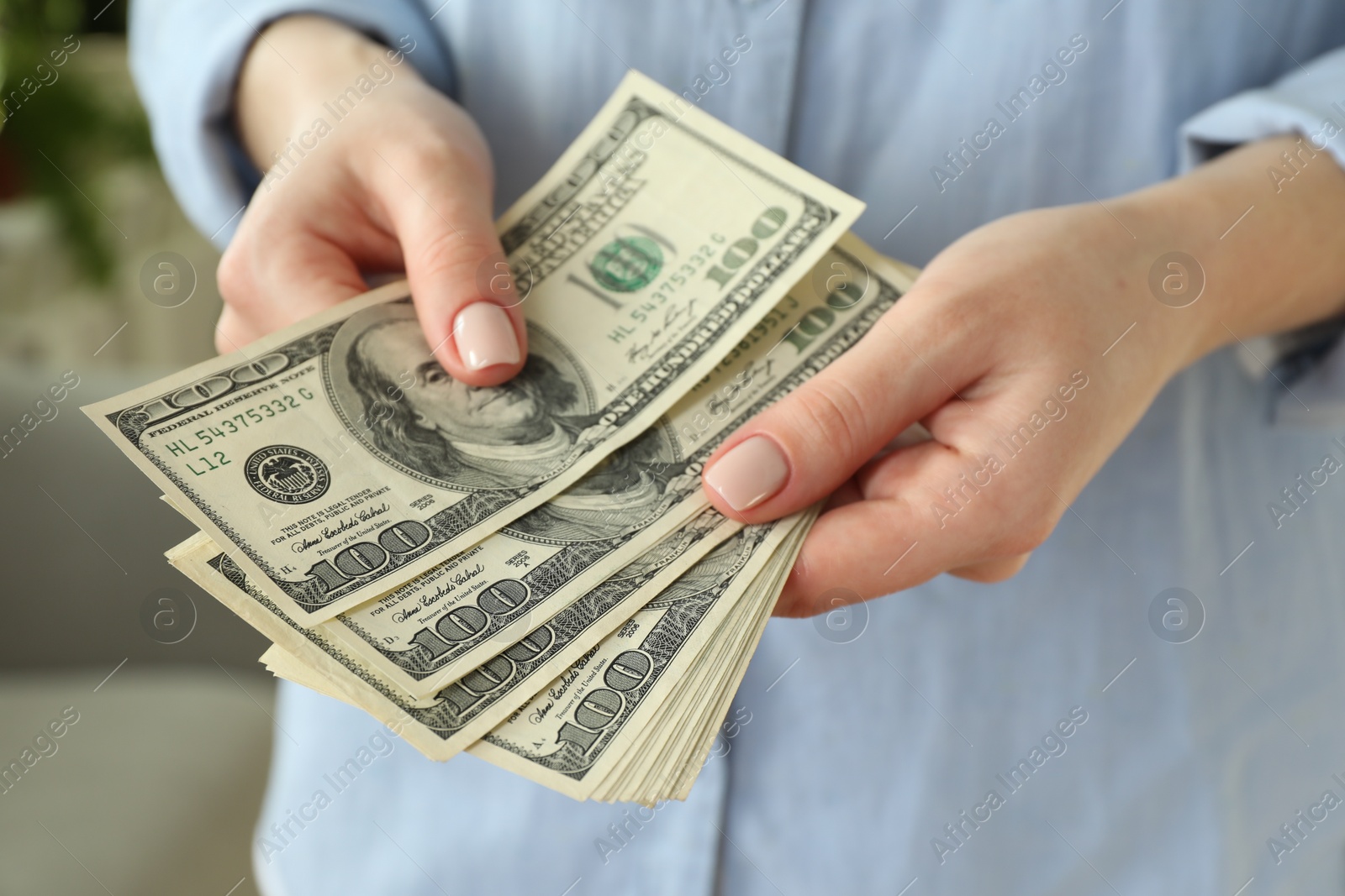 Photo of Money exchange. Woman counting dollar banknotes on blurred background, closeup