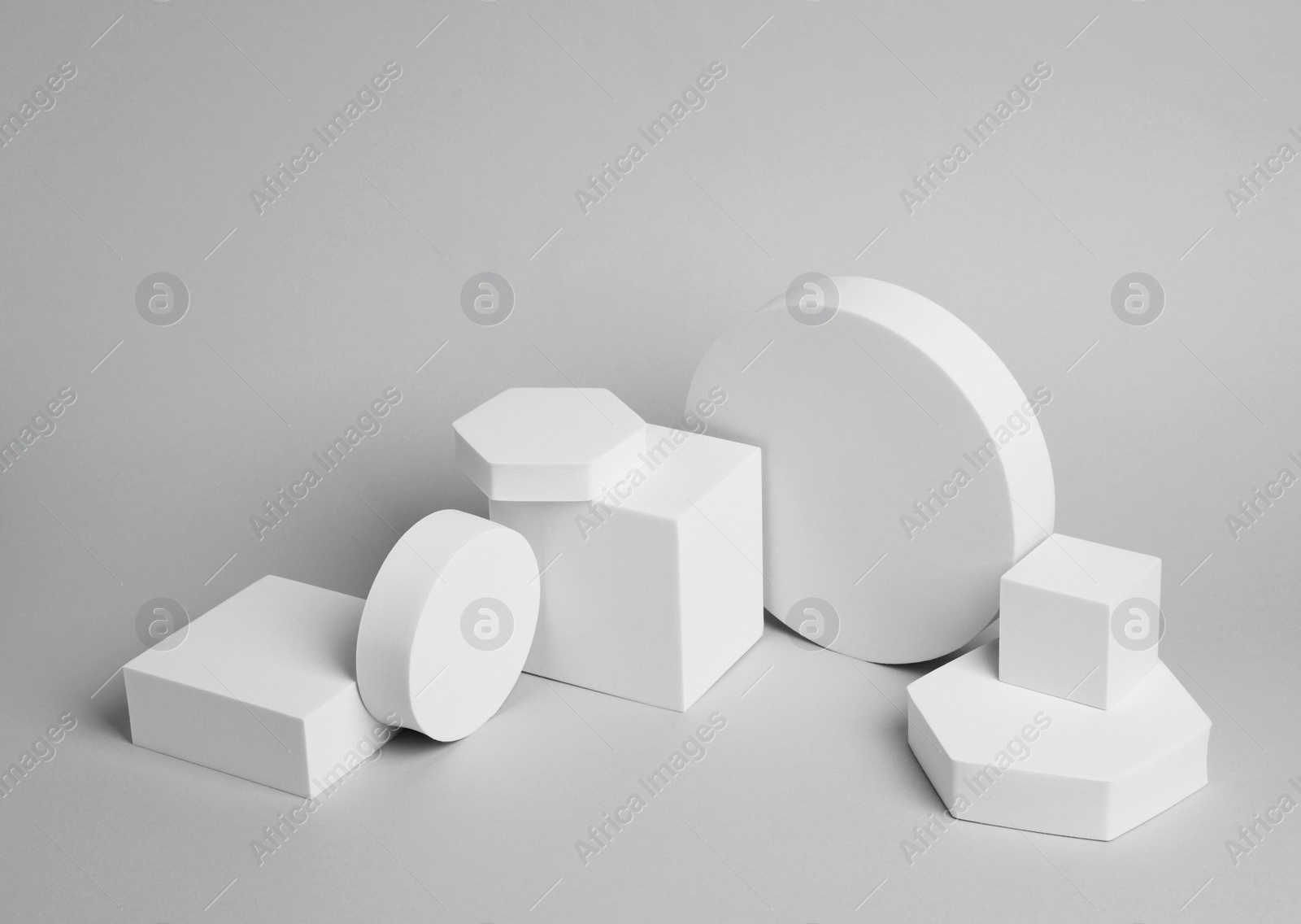 Photo of Scene for product presentation. Podiums of different geometric shapes on light grey background