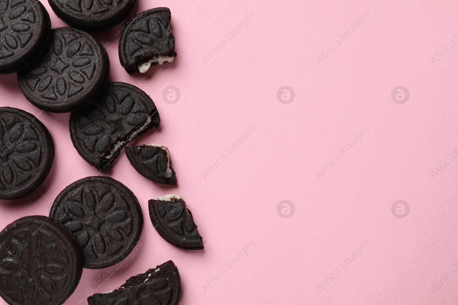 Photo of Tasty sweet sandwich cookies on pink background, flat lay. Space for text