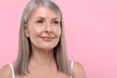 Photo of Portrait of beautiful senior woman on pink background. Space for text
