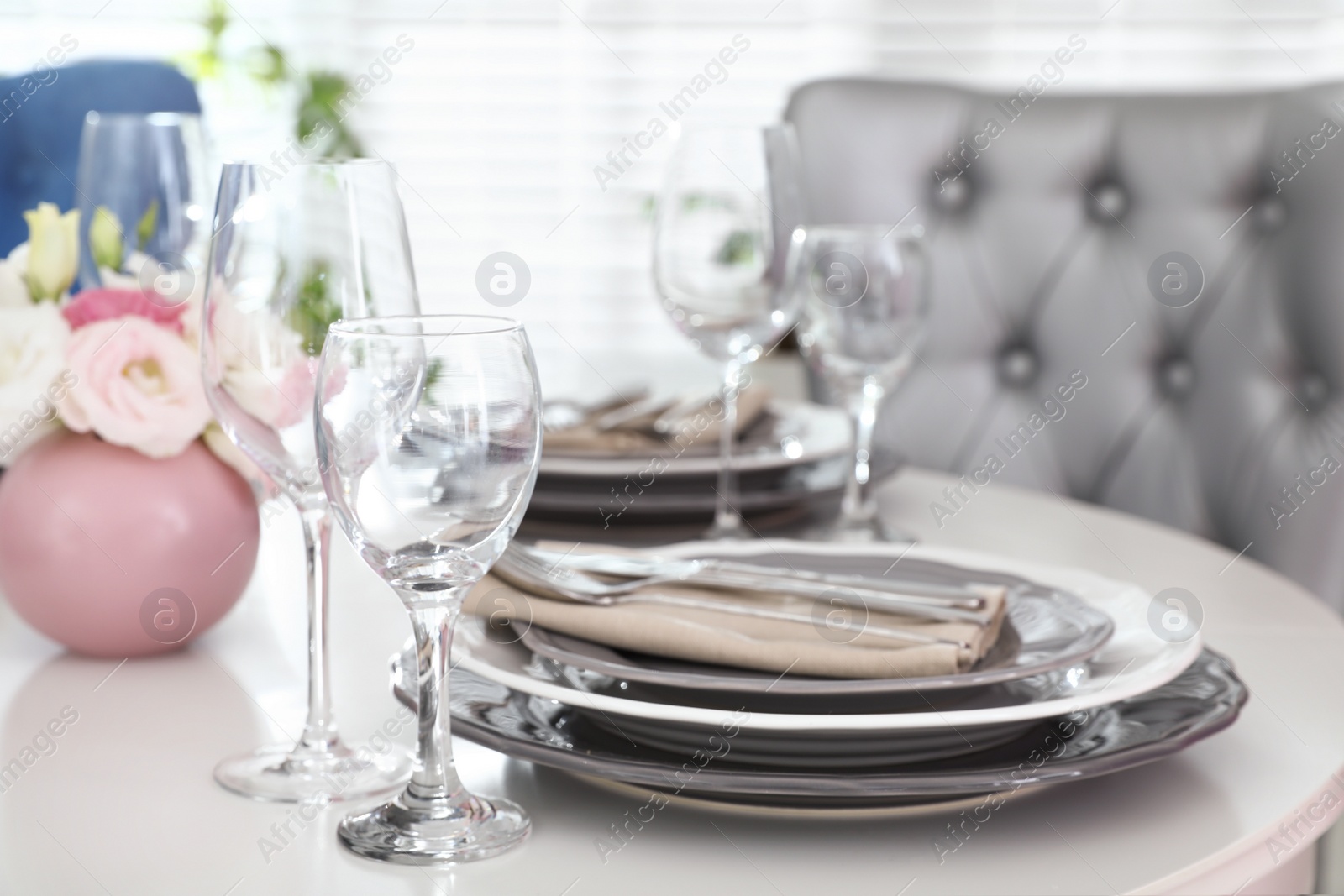 Photo of Beautiful table setting in modern dining room interior