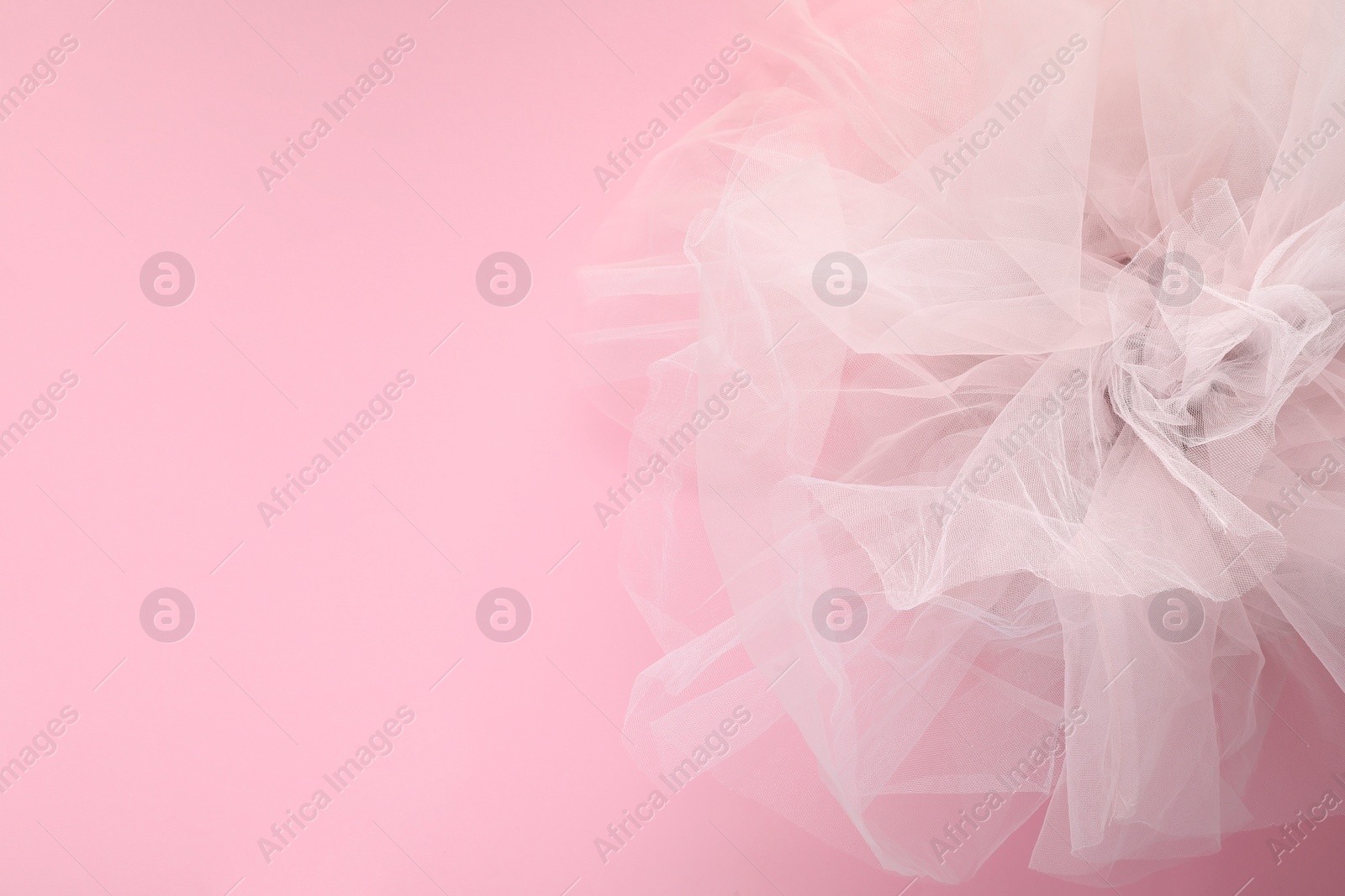 Photo of Beautiful tulle fabric on pink background, top view. Space for text