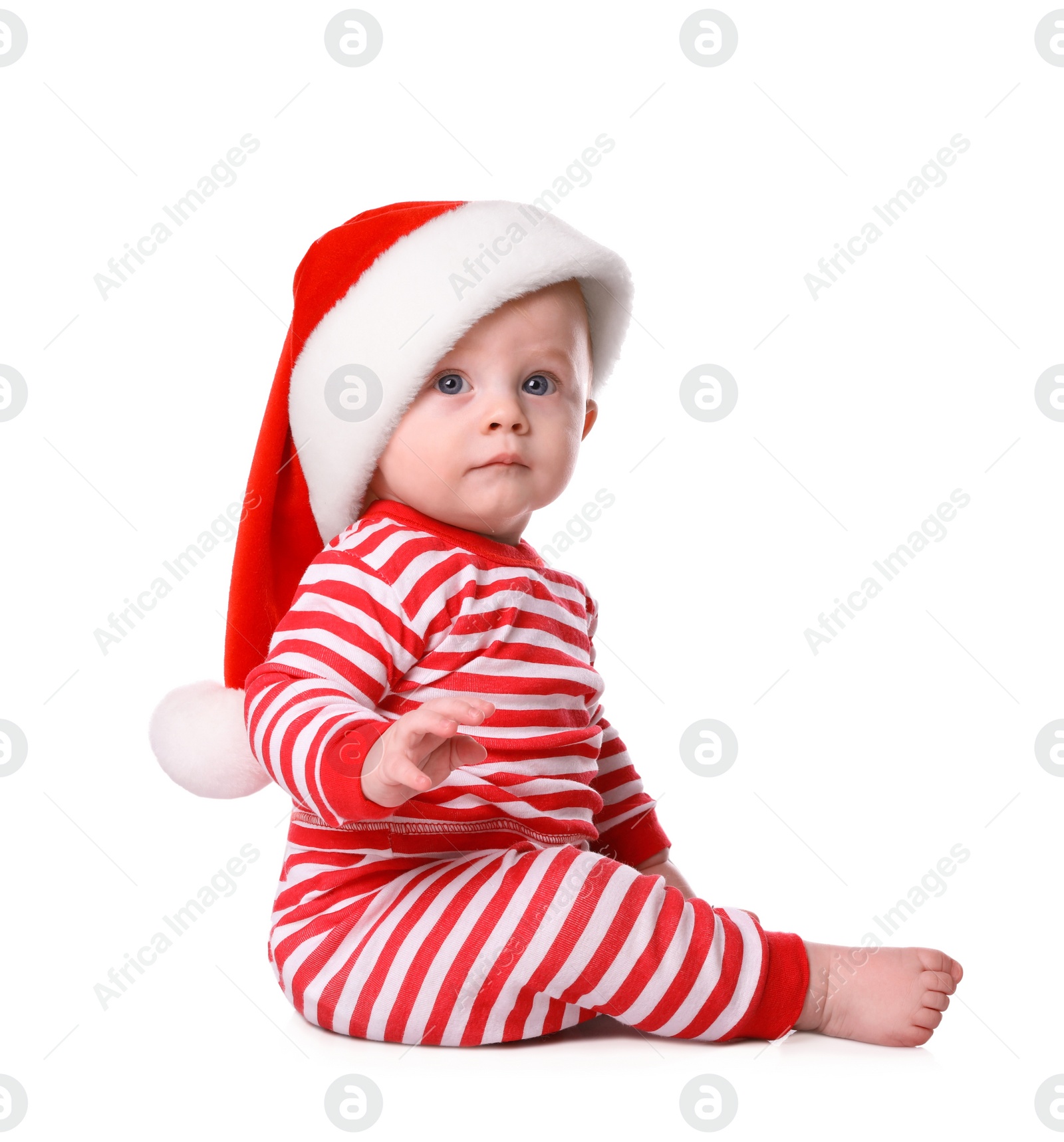 Photo of Cute baby in Santa hat and bright Christmas pajamas on white background