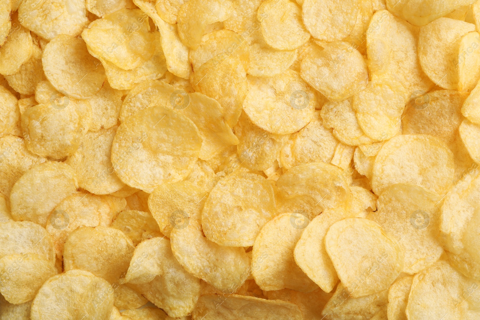 Photo of Crispy potato chips as background, top view