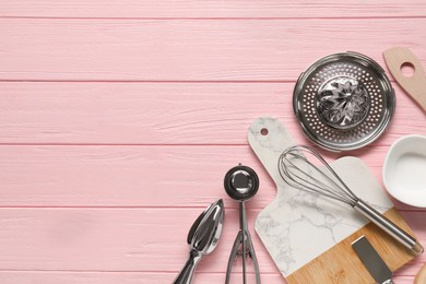 Photo of Set of different kitchen utensils on pink wooden table, flat lay. Space for text