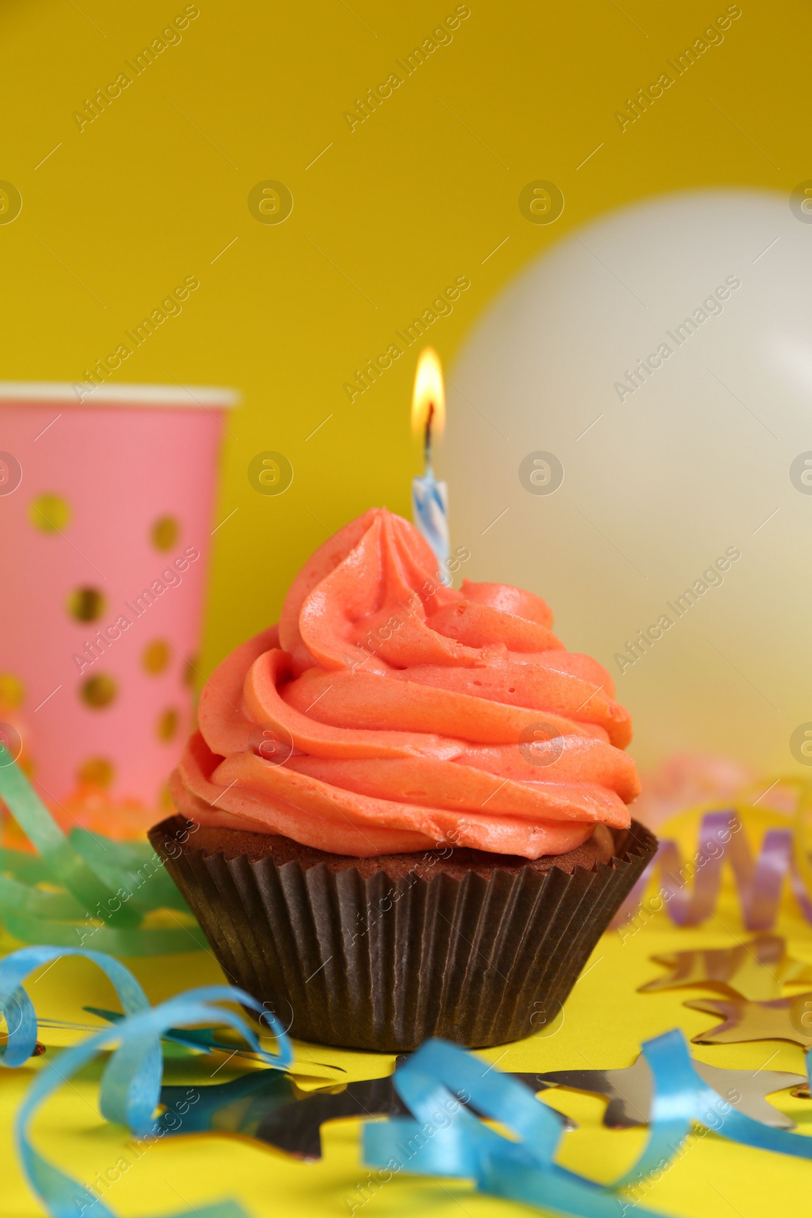 Photo of Delicious birthday cupcake with bright cream on yellow background