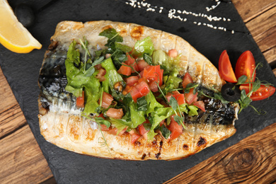 Photo of Delicious grilled fish served on wooden table, top view