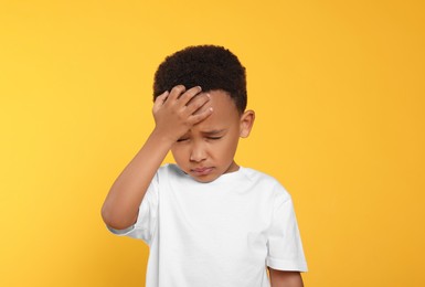 Photo of Portrait of emotional African-American boy on yellow background