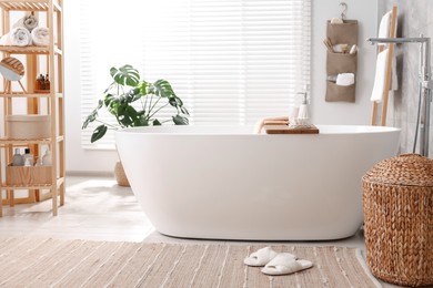 Photo of Set of different bath accessories and soap on tub in bathroom
