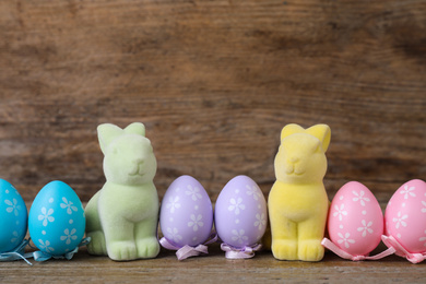 Easter bunnies and painted eggs on wooden background