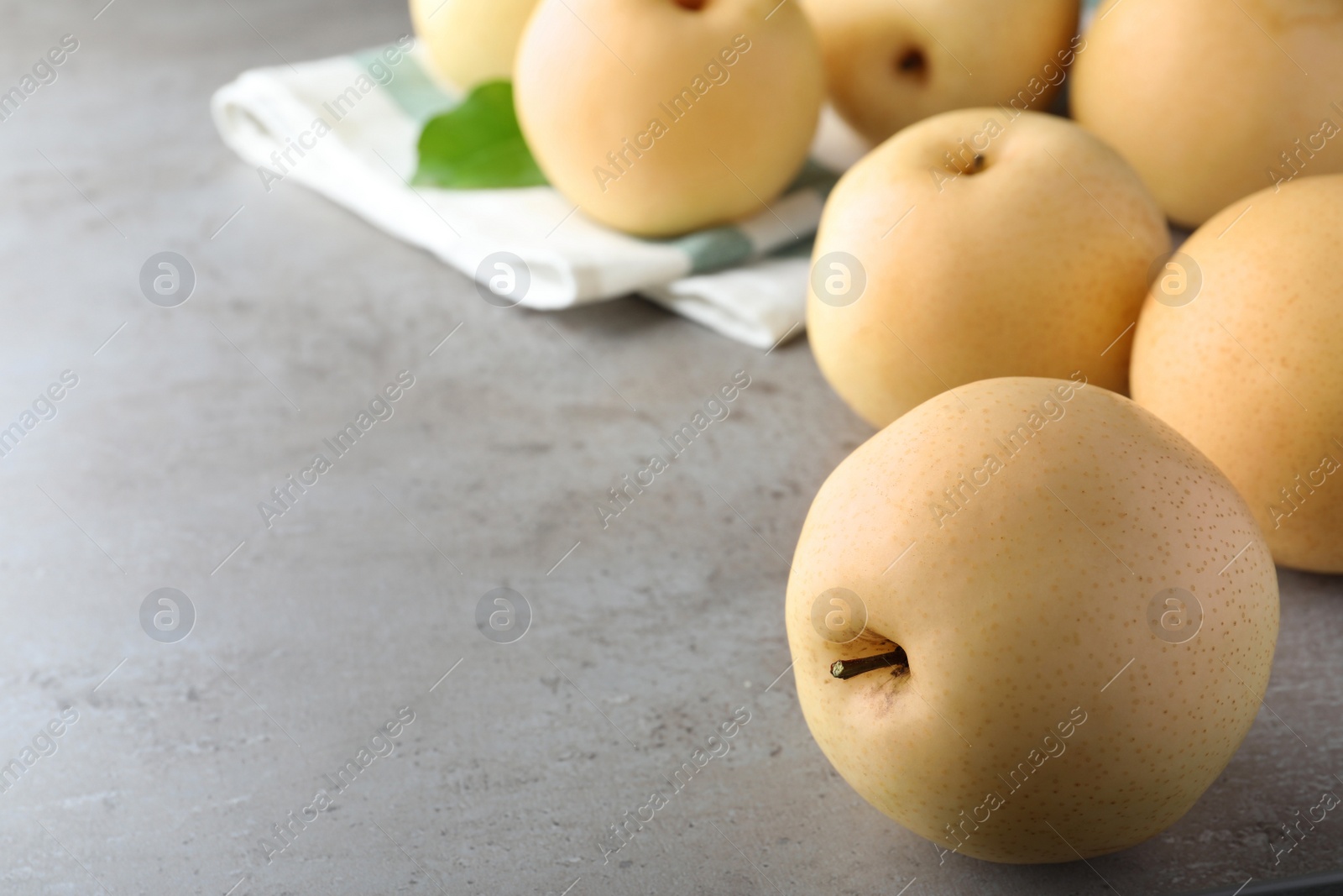 Photo of Fresh apple pears on grey table, space for text