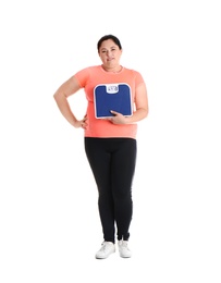 Photo of Overweight woman in sportswear with scales on white background