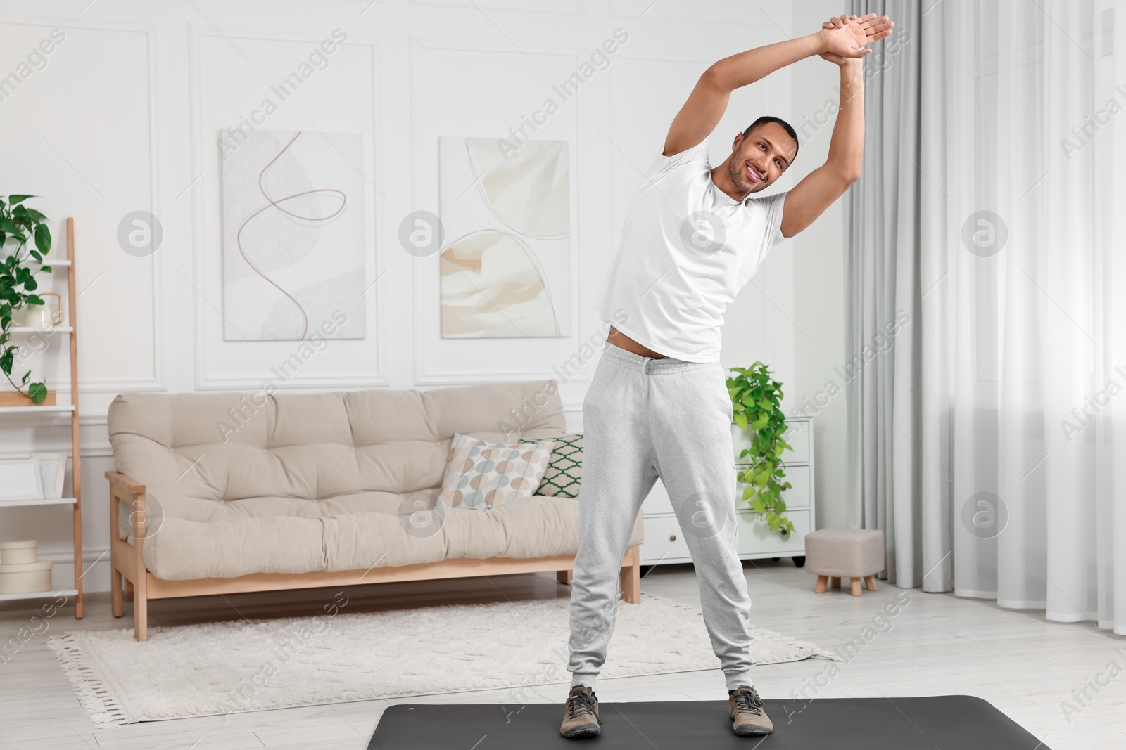 Photo of Man doing morning exercise on fitness mat at home