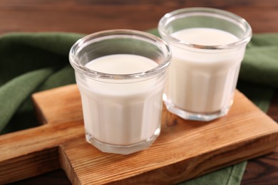 Photo of Glasses of tasty milk on table, closeup