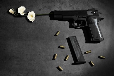 Image of Beautiful flowers, bullets and handgun on grey table, flat lay. Peace instead of war