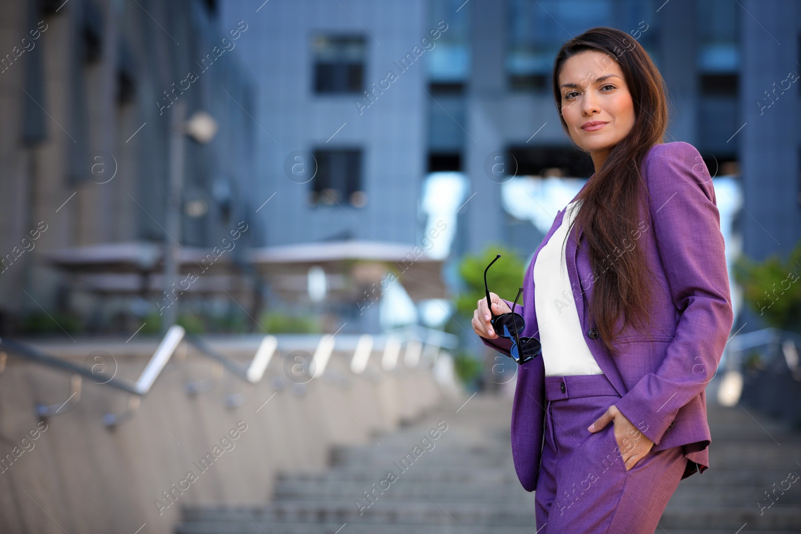 Photo of Beautiful businesswoman with sunglasses on city street. Space for text