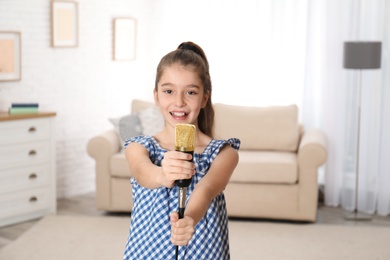 Photo of Cute girl with microphone in living room